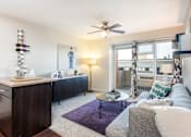 Thumbnail 2 of 18 - A living room with a grey couch and a purple rug.
