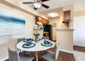 Thumbnail 6 of 33 - a dining area with a table and chairs and a ceiling fan
