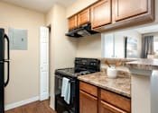 Thumbnail 7 of 33 - an updated kitchen with black appliances and granite counter tops