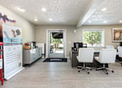 Thumbnail 33 of 33 - a break room with white chairs and a desk and a doorway