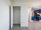 Thumbnail 13 of 35 - Living room and kitchen with navy cabinets and wood floor