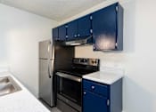 Thumbnail 15 of 35 - kitchen with navy cabinets and a black refrigerator