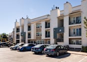 Thumbnail 13 of 16 - an apartment building with cars parked in front of it