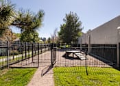 Thumbnail 15 of 16 - a fenced in area with a fire pit and a fence