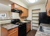Thumbnail 5 of 16 - an updated kitchen with granite counter tops and black appliances