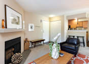 Thumbnail 3 of 16 - a living room with a fireplace and a couch and a table