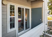 Thumbnail 11 of 16 - the front of the house has three windows and a door