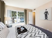 Thumbnail 7 of 16 - a bedroom with a bed and a picture of a man on the wall