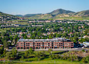 Thumbnail 26 of 29 - A large red building sits in the middle of a green field.