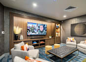 Thumbnail 24 of 29 - A modern living room with a flat screen TV mounted on the wall.