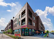Thumbnail 17 of 29 - A large brick building with a red awning and a sign that reads