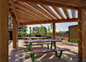 Thumbnail 15 of 29 - A wooden pergola with green benches is in the foreground.