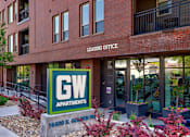Thumbnail 29 of 29 - A red brick building with a green and white sign that says GW Apartments.