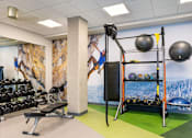 Thumbnail 13 of 29 - A gym with a wall mural of a climber and a green floor.