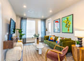 Thumbnail 1 of 29 - A living room with a green couch, a white coffee table, and a painting on the wall.