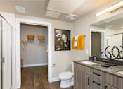 Thumbnail 4 of 29 - A bathroom with a toilet, sink, and mirror.