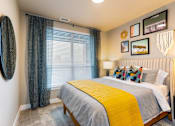 Thumbnail 5 of 29 - A bedroom with a bed, a mirror, a chandelier, and pictures on the wall.