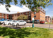 Thumbnail 9 of 31 - a parking lot with cars in front of an apartment building