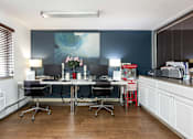 Thumbnail 2 of 31 - an office with desks and chairs and a painting on the wall