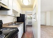 Thumbnail 19 of 31 - a kitchen with a stove and a sink and a refrigerator