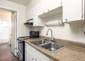 Thumbnail 20 of 31 - a kitchen with a sink and a stove and a window
