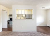 Thumbnail 18 of 31 - an empty living room and kitchen with a hard wood floor