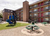Thumbnail 8 of 31 - a playground in the courtyard of an apartment building with a blue slide