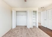Thumbnail 31 of 31 - a bedroom with white closets and a carpeted floor