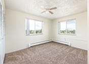 Thumbnail 23 of 31 - an empty bedroom with a ceiling fan and two windows