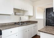 Thumbnail 25 of 31 - a kitchen with white cabinets and a sink and a refrigerator