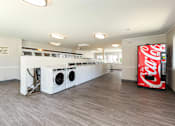 Thumbnail 27 of 35 - a laundry room with a coca cola coke machine