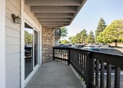 Thumbnail 12 of 35 - the porch of a building with a balcony and cars in the parking lot