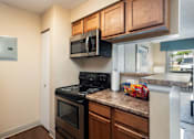 Thumbnail 16 of 35 - a kitchen with a stove and microwave and a counter with a sink