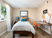 Thumbnail 21 of 35 - a bedroom with a bed and a desk and a window