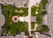 Thumbnail 49 of 50 - an aerial view of a building shaped like a face with grass and trees