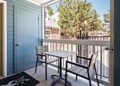 Thumbnail 12 of 50 - a balcony with a table and chairs and a blue door