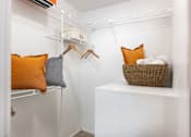 Thumbnail 10 of 50 - a walk in closet with pillows and a basket on a shelf in a closet