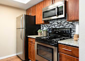 Thumbnail 5 of 50 - a kitchen with black appliances and a stainless steel refrigerator