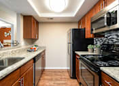 Thumbnail 3 of 50 - a kitchen with stainless steel appliances and granite counter tops