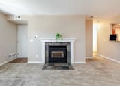 Thumbnail 8 of 50 - a living room with a fireplace and a carpeted floor