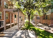 Thumbnail 13 of 50 - a sidewalk in front of a brick building with trees