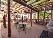 Thumbnail 35 of 50 - a patio with tables and chairs and a wooden deck