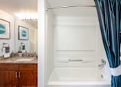 Thumbnail 21 of 50 - a bathroom with a shower and a sink and a bath tub