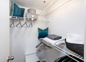 Thumbnail 20 of 50 - a laundry room with a chair and a shelf with towels on it