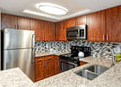 Thumbnail 18 of 50 - a kitchen with granite counter tops and stainless steel appliances