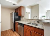 Thumbnail 24 of 50 - an empty kitchen with a stainless steel refrigerator and sink