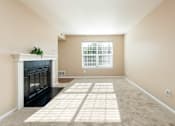 Thumbnail 25 of 50 - an empty living room with a fireplace and a window
