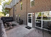 Thumbnail 13 of 39 - a patio with chairs and a table outside of a brick building