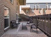 Thumbnail 14 of 39 - a patio with chairs and a table outside of a brick building