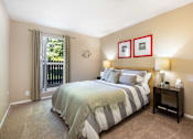 Thumbnail 10 of 39 - a bedroom with a bed and a door to a balcony